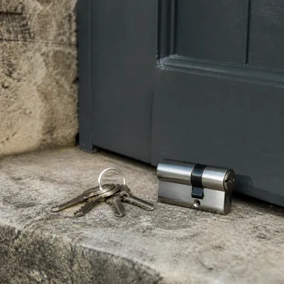 Bombín recién colocado y llaves en el umbral de una puerta de Barcelona, sin rostros